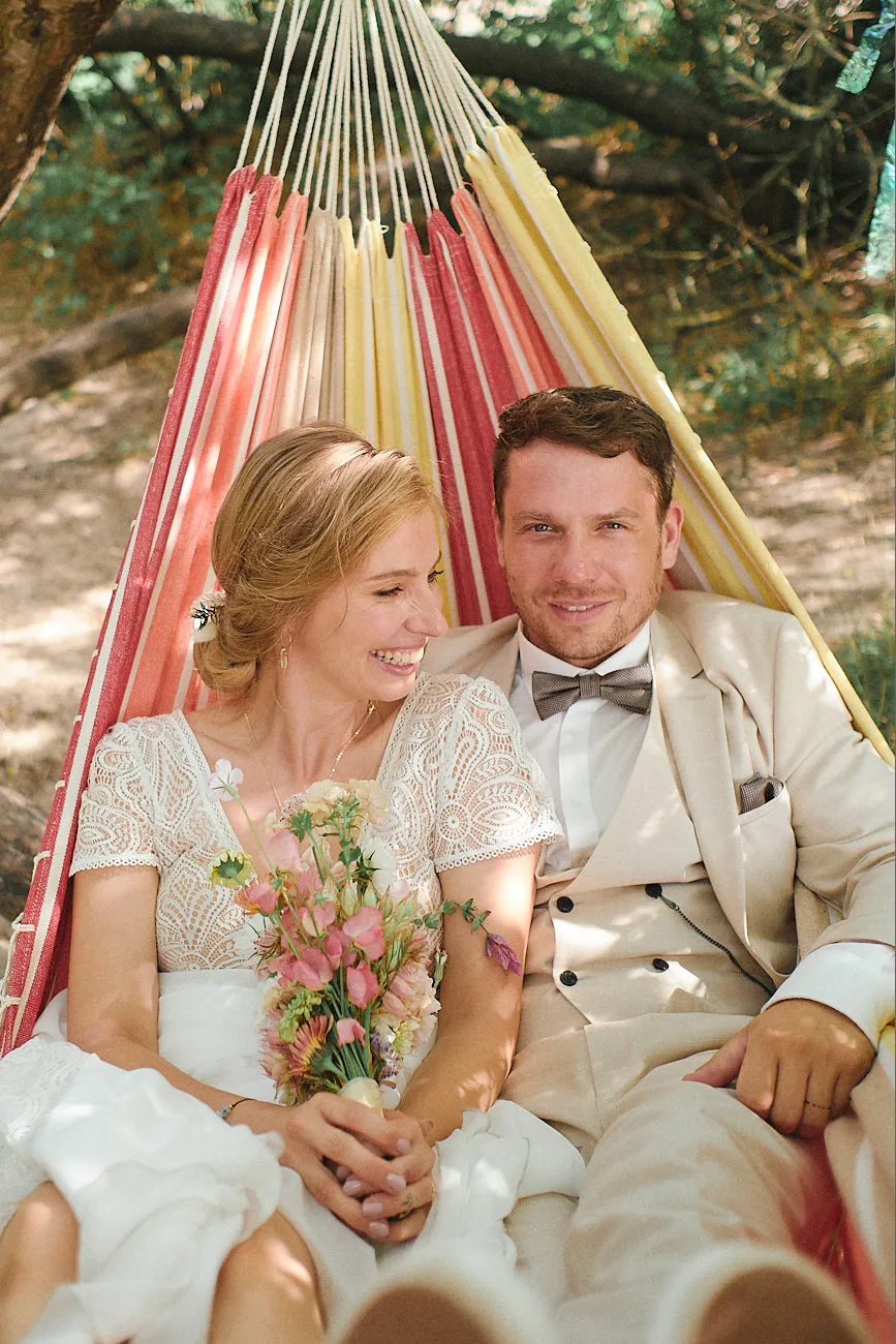 Hochzeitspaar liegt in der Hängematte und genießt den Tag.