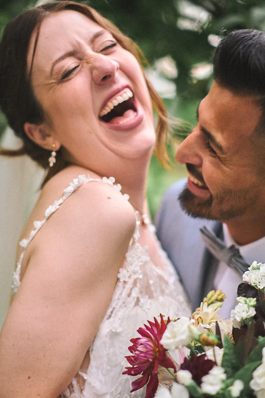 Ein albernes Hochzeitspaar verliert die Haltung vor Lachen. Ein lustiges Bild.